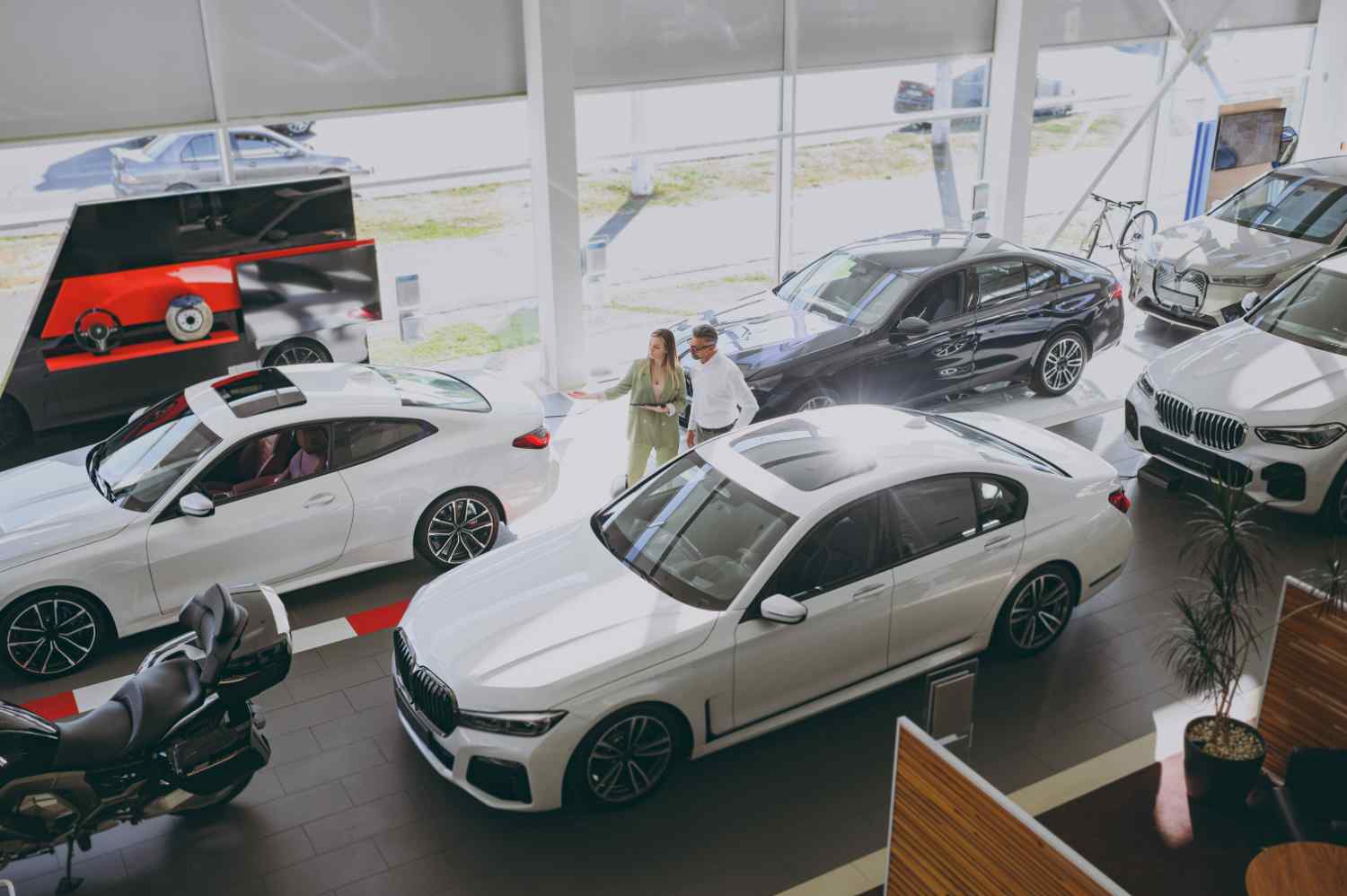 Two people looking at cars in a dealership
